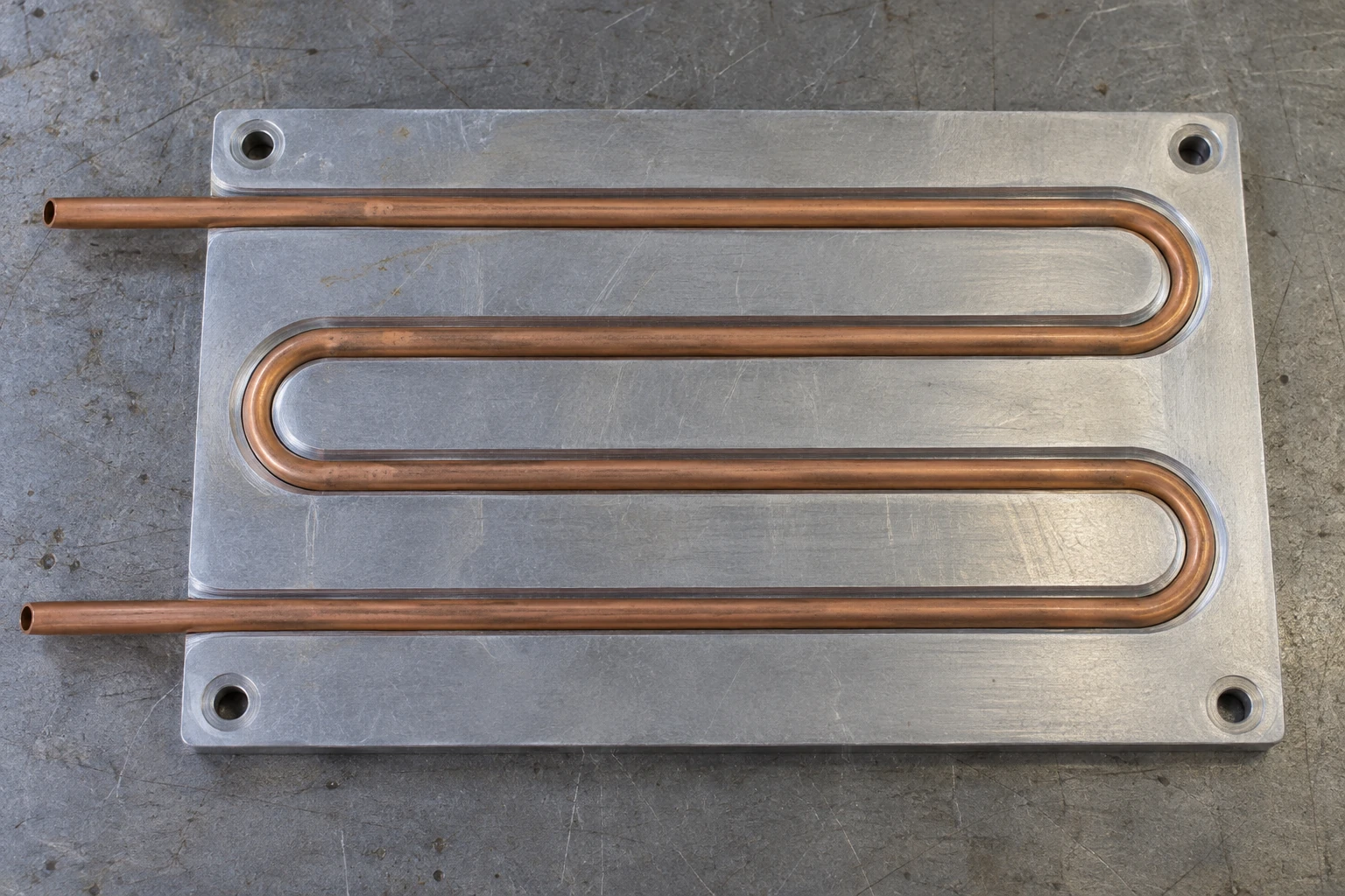 Continuous four-pass copper tube supported in machined aluminum grooves