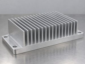 Structural integrity aluminum heat sink sample with a thick base and broad mounting ears